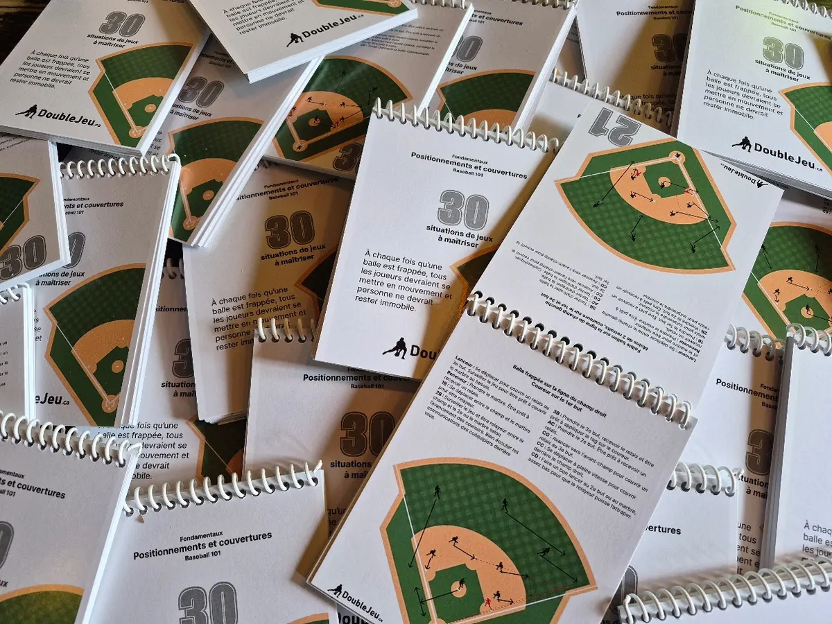 Une pile de carnets de jeu DoubleJeu, reliés par spirale, montrant la couverture « Positionnements et couvertures — 30 situations de jeux à maîtriser » et une page intérieure.